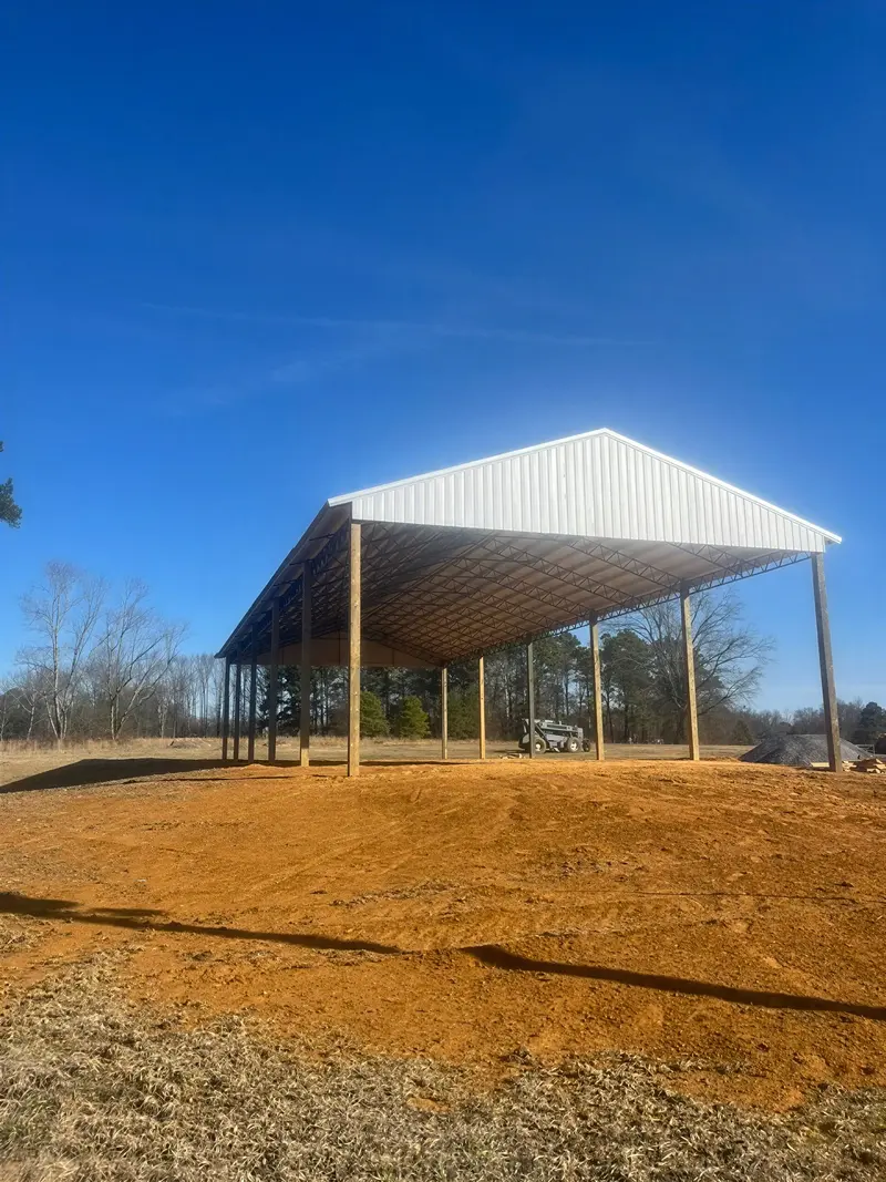 Roofed steel frame with open sides on a prepared building site