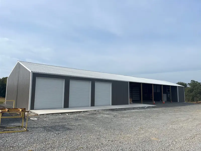Long metal building with multiple garage doors and open equipment bays