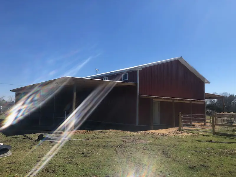 Red barn with a covered side bay