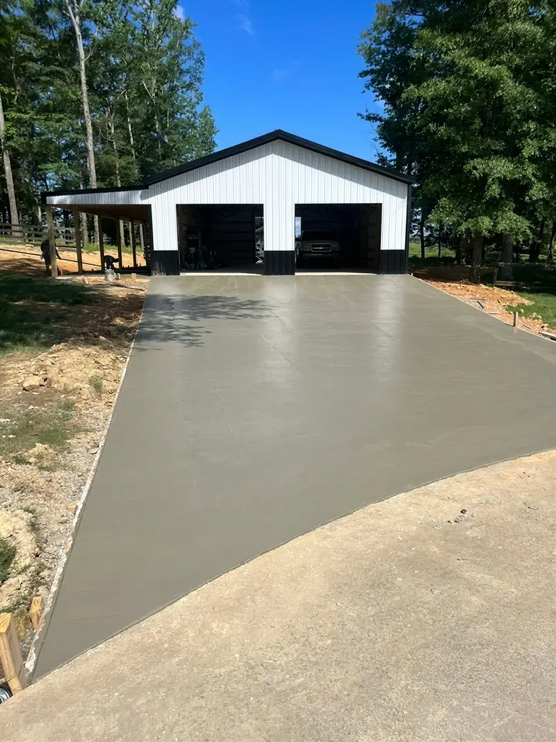 White metal garage at the end of a paved driveway