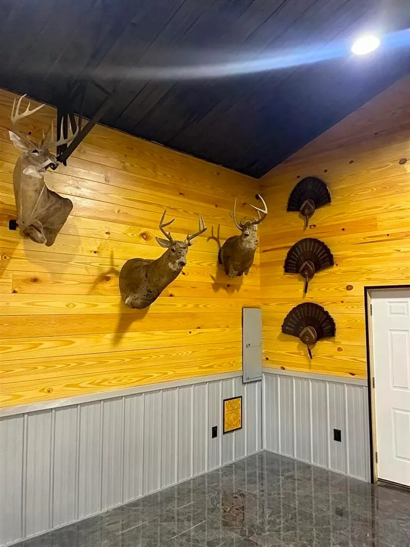 Barndominium interior with wood-paneled walls, mounted wildlife, and metal wainscoting