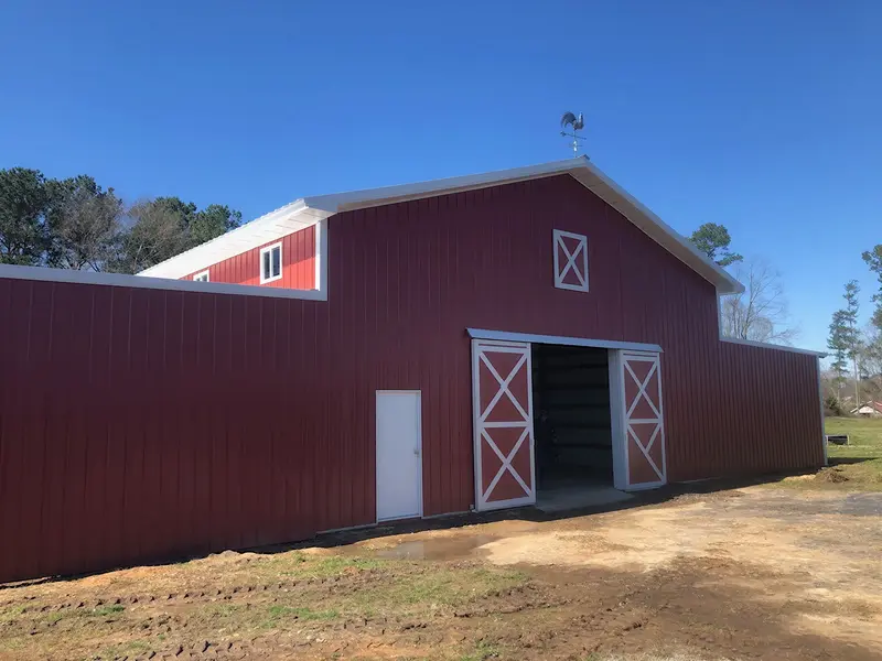 Red barn with white trim and sliding barn doors